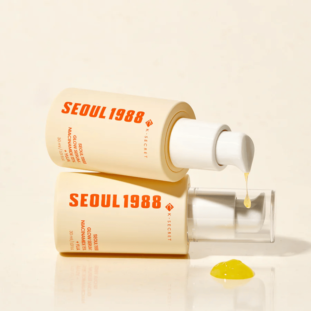 To flasker Seoul 1988 Glow Serum liggende og stående, med gult serum dryppende fra pumpen.