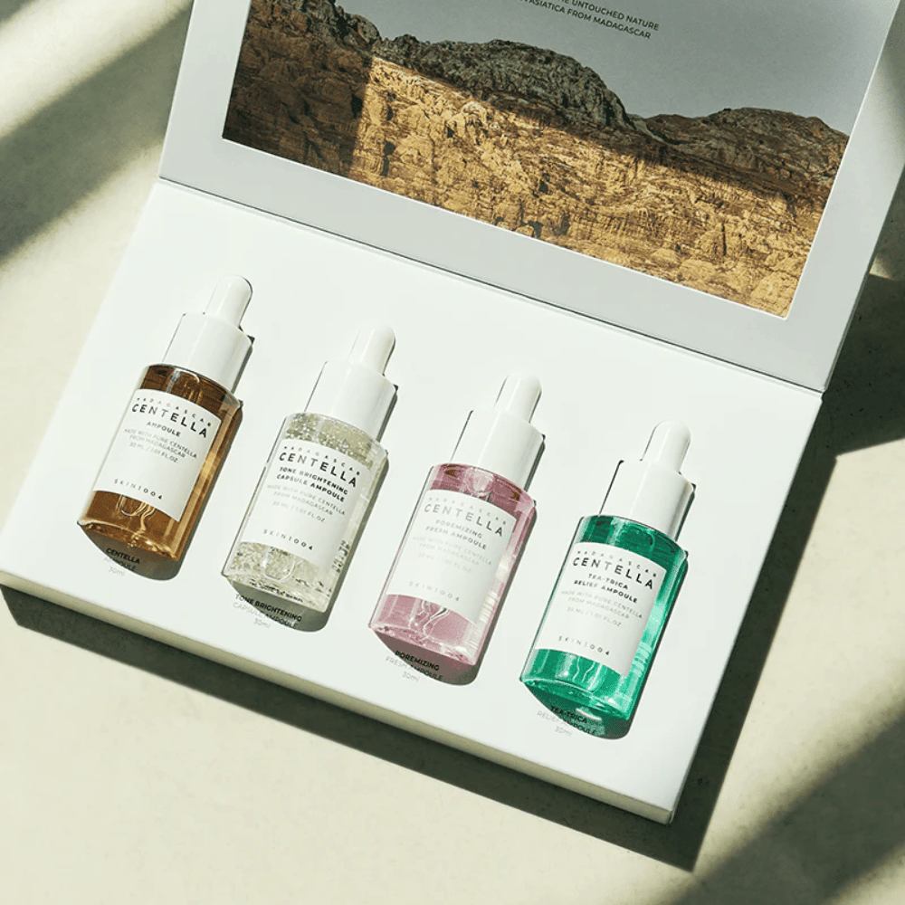 En eske som inneholder Madagascar Centella Ampoule Kit fra SKIN1004, som inneholder tre forskjellige typer hudpleieprodukter for fuktighet og fuktighet.