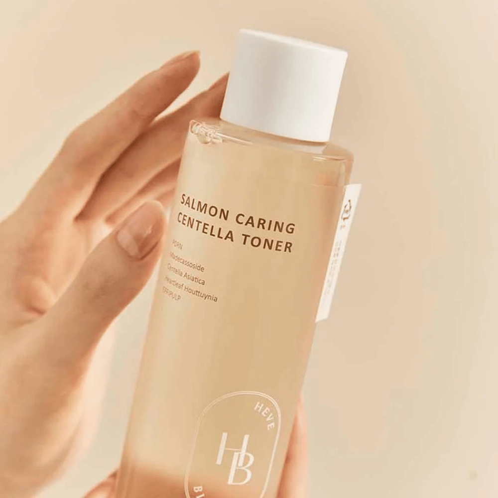 Nærbilde av Salmon Caring Centella Toner i hånd – beroligende toner med PDRN og planteekstrakt som hjelper til med å styrke huden og redusere følelsen av irritasjon.