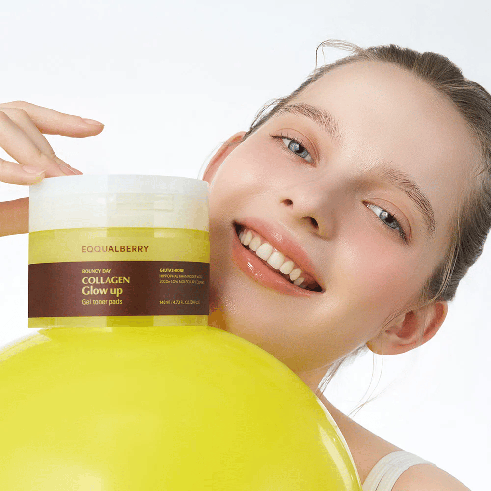 Smilende modell som holder Bouncy Day Collagen Glow up Gel Toner Pads, som hjelper til med å gi en ungdommelig glød og fasthet med lav molekylær kollagen og glutation.