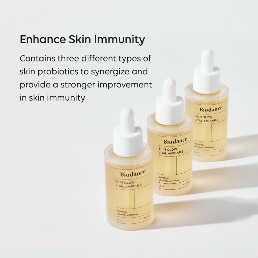 Tre flasker av Biodance Skin Glow Vital Ampoule vises med teksten 'Enhance Skin Immunity'. Produktet inneholder tre forskjellige typer hudprobiotika som styrker hudens immunitet og forbedrer dens beskyttelse.