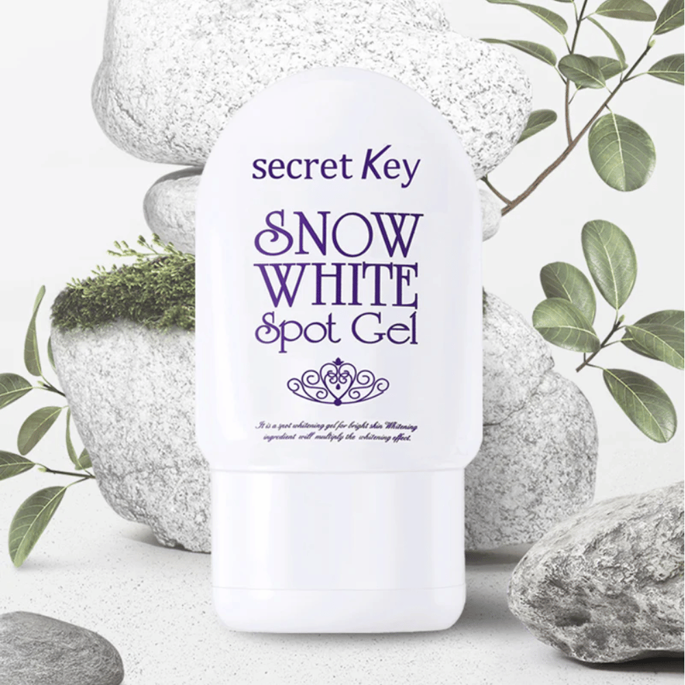 Secret Key Snow White Spot Gel fotografert mot steiner og grønne blader.