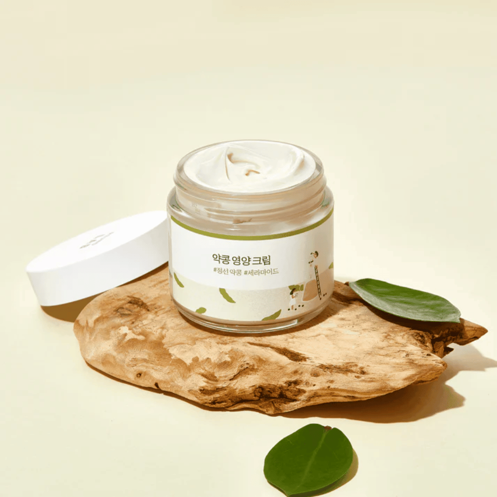 Mixsoon Soybean Nourishing Cream i åpen krukke på et trestykke med grønne blader. En næringsrik krem med fermenterte soyabønner og ceramider.