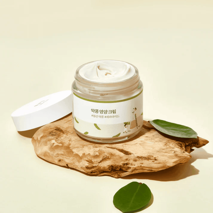 Mixsoon Soybean Nourishing Cream i öppen burk på ett trästycke med gröna blad. En näringsrik kräm med fermenterade sojabönor och ceramider.