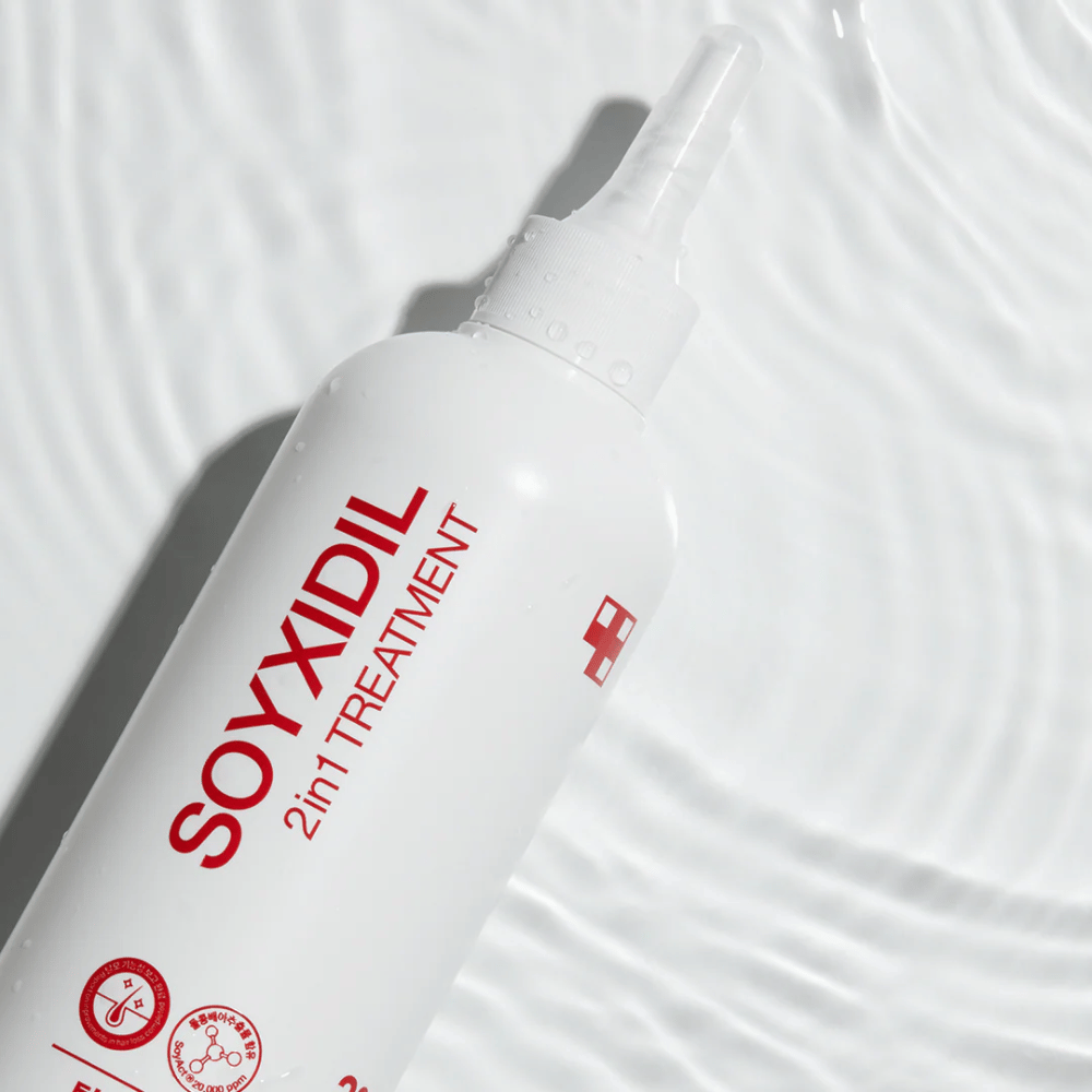 Flaske av Medicube Soyxidil 2in1 Treatment ligger på bølgete vannoverflate, som symboliserer fuktgivende og oppfriskende pleie.