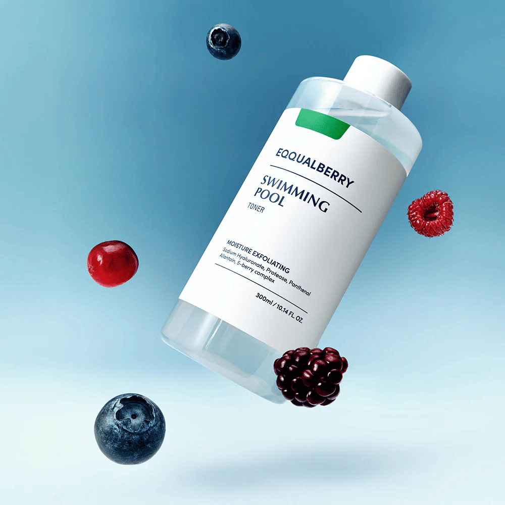 Equalberry Swimming Pool Toner i en stilren flaske svevende mot blå bakgrunn, omgitt av friske bær som blåbær, bringebær og bjørnebær.