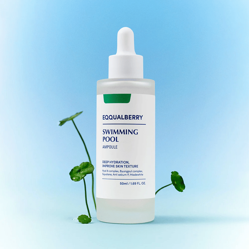 Flaske med Eqqualberry Swimming Pool Ampoule, et hudpleieprodukt for dyp fuktighet og forbedret hudstruktur, plassert på en lyseblå bakgrunn med noen grønne planter i forgrunnen.