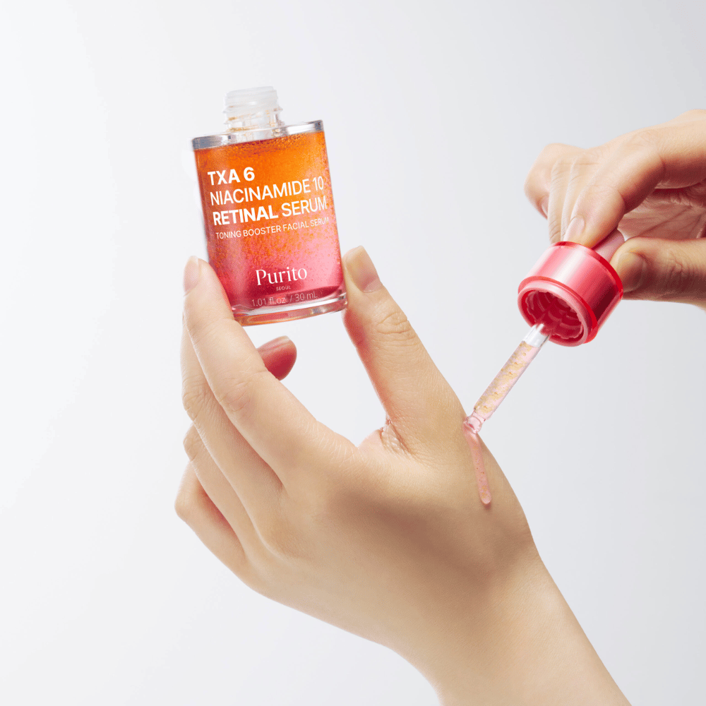 Hånd påfører Purito TXA 6 Niacinamide 10 Retinal Serum. Lett formel med aktive ingredienser for glød, elastisitet og klarere hud.