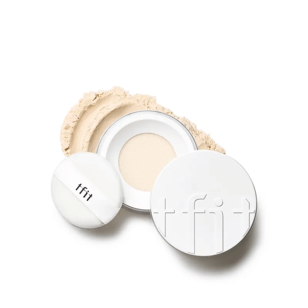 Åpen boks med TFIT Translucent Set Finishing Powder i nyansen Skin Beige, med medfølgende puff og setting powder spredt rundt.