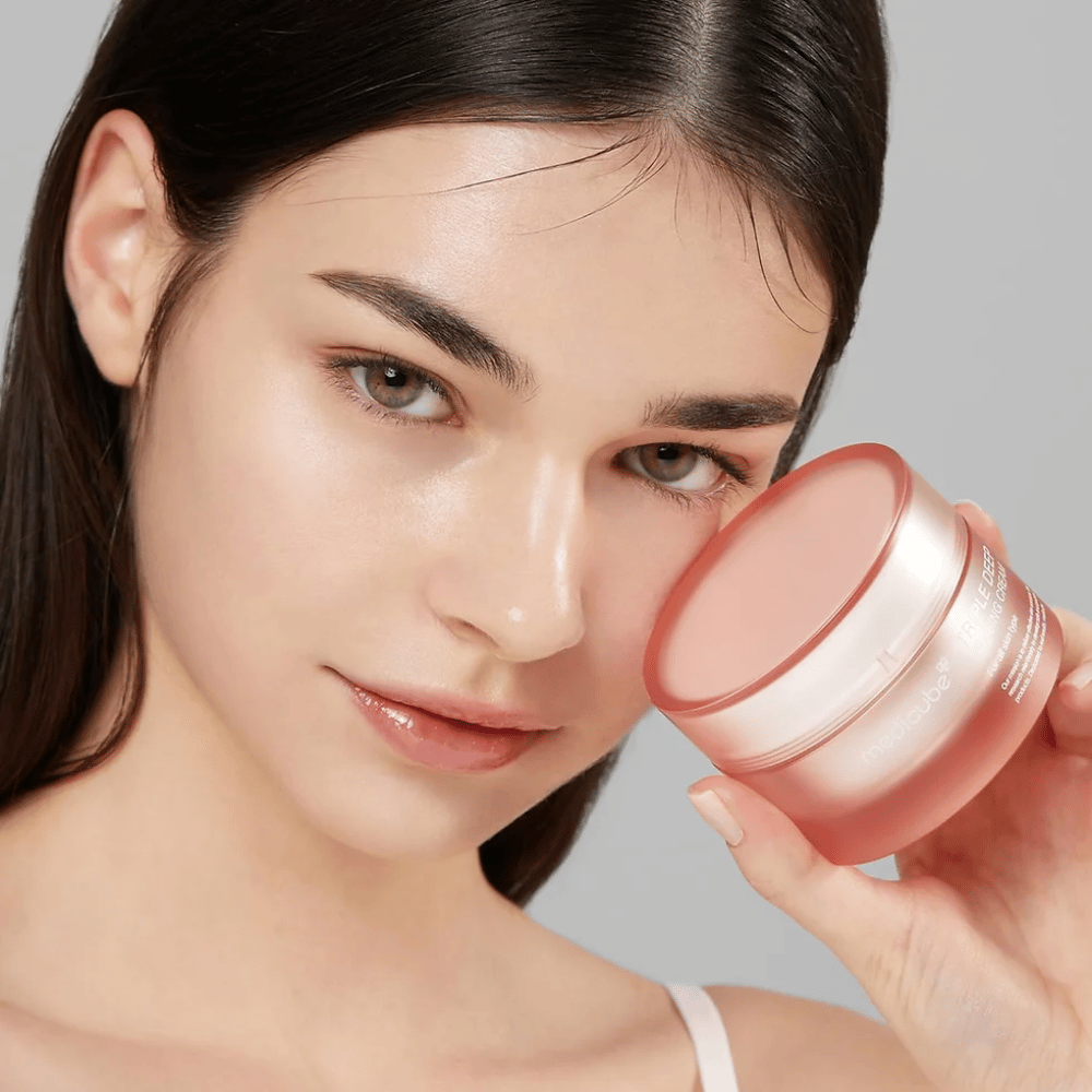 Bildet viser en kvinne som holder en krukke med Triple Collagen Cream. Kremen er designet for å forbedre hudens elastisitet og fuktighet. Kvinnens hud ser glatt og velstelt ut.




