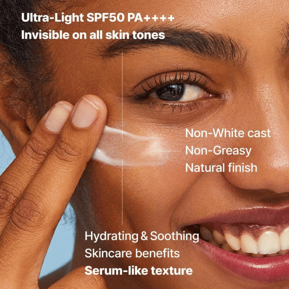 Nærbilde av en kvinne som påfører en gjennomsiktig solkrem med fingrene; tekst fremhever SPF50 PA++++, ingen hvit hinne, naturlig finish og serumlignende fuktighetsgivende tekstur.