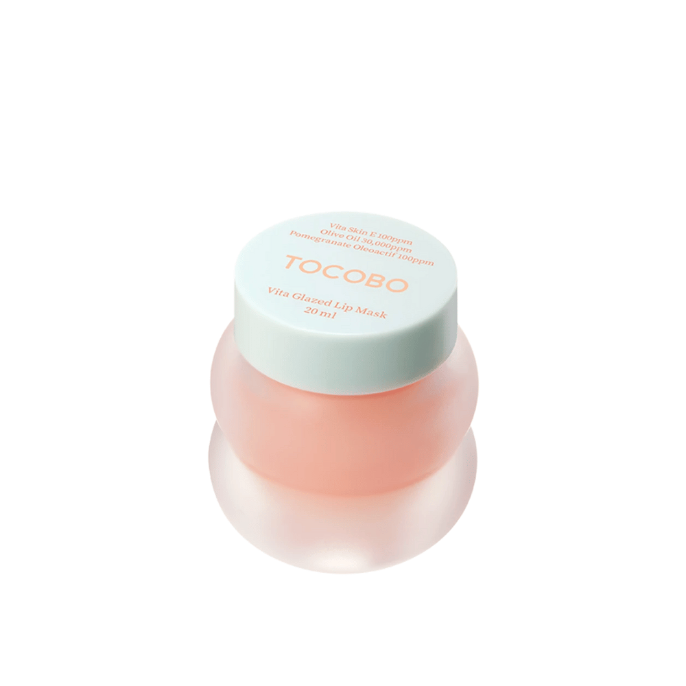 En krukke med "Vita Glazed Lip Mask" fra Tocobo vises. Krukken er rund og gjennomsiktig med et lyst turkist lokk. Masken inni er lett rosa og designet for å fukte og pleie leppene. Produktet har et volum på 20 ml.