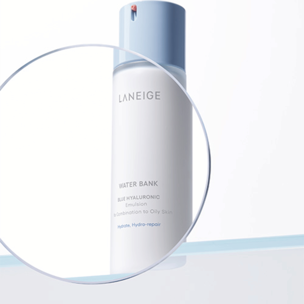 LANEIGE Water Bank Blue Hyaluronic Emulsion med lyseblå pumpe, sett gjennom et forstørret glass mot hvit bakgrunn med blå kant.