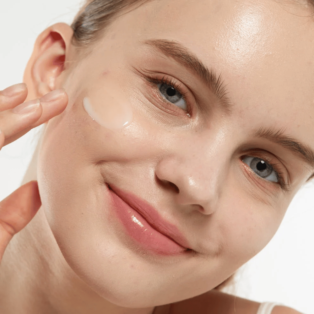 Modell som påfører Medicube Zero Pore Serum 2.0 på kinnet, et porforbedrende serum som gir jevnere hudstruktur, fuktighet og en naturlig glød.