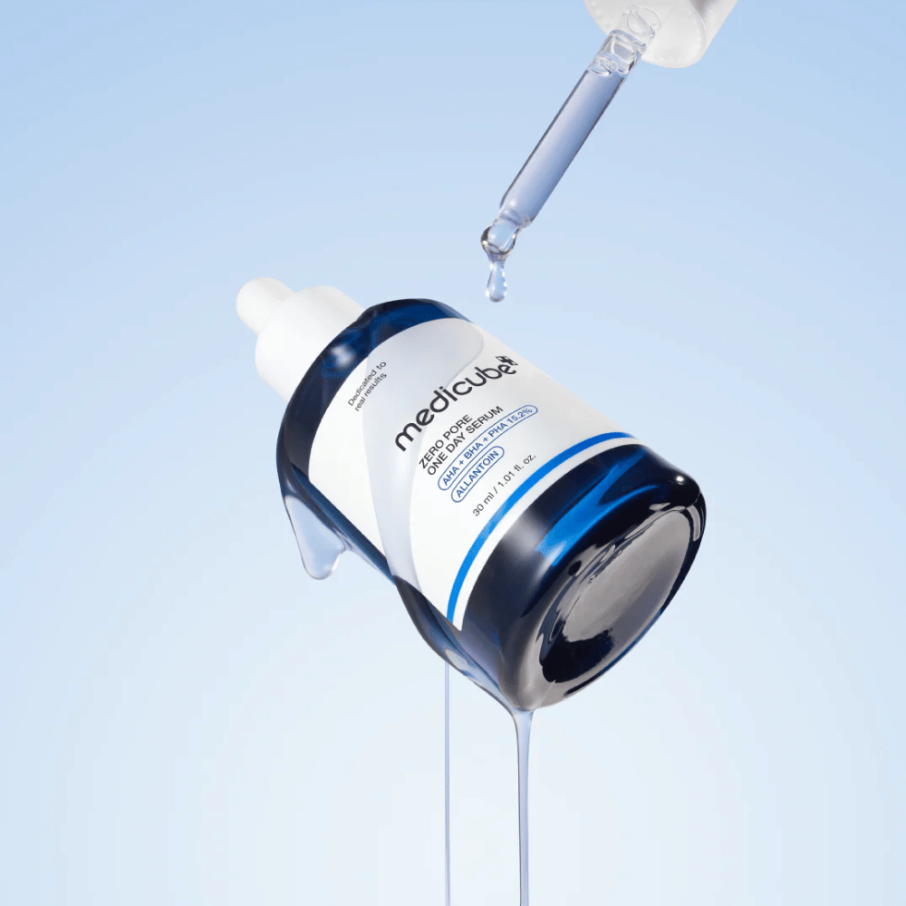 Flaske av Medicube Zero Pore One Day Serum med pipette og rennende serumdråper mot en lys blå bakgrunn.