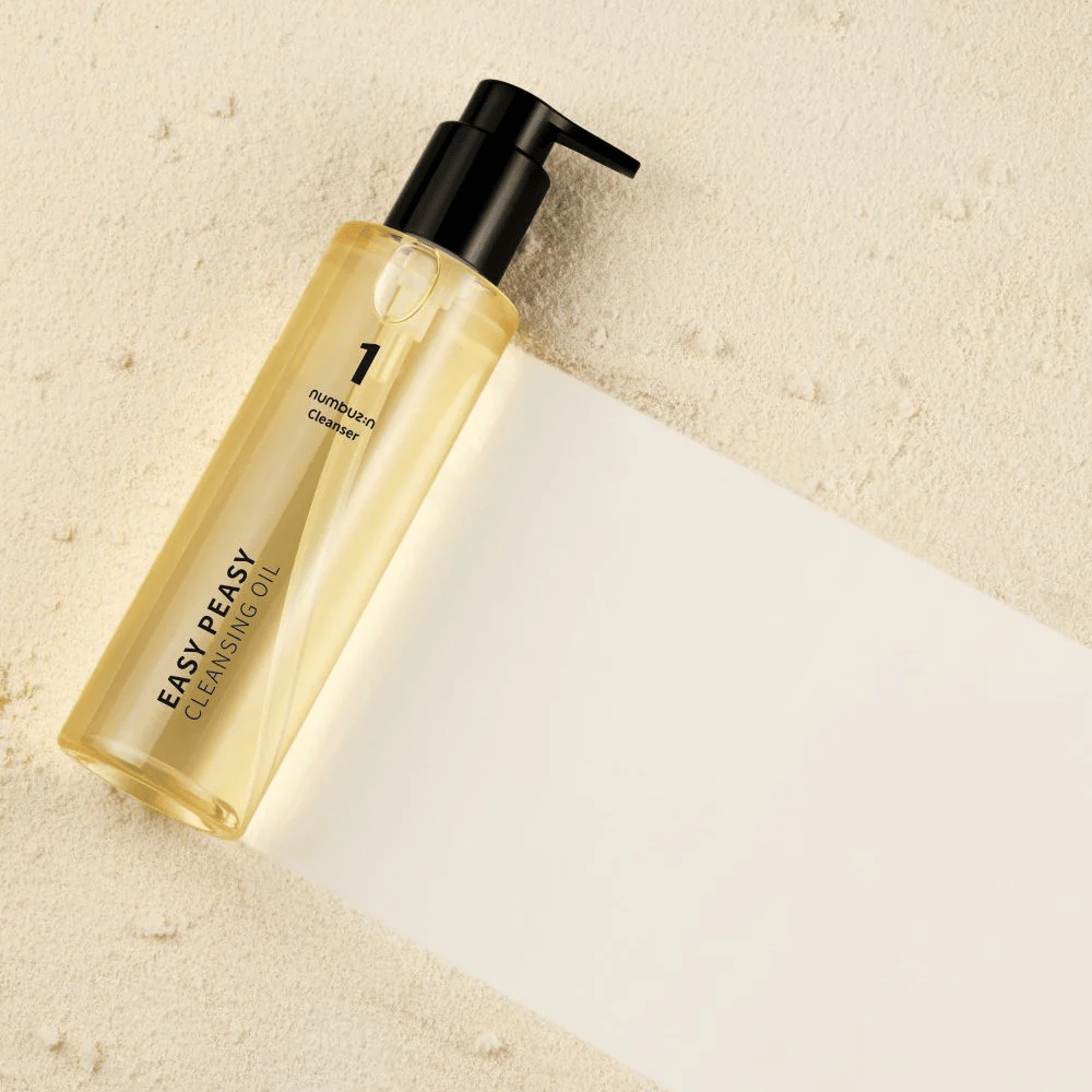 Numbuzin No.1 Easy Peasy Cleansing Oil liggende på sandfarget overflate med skygge.