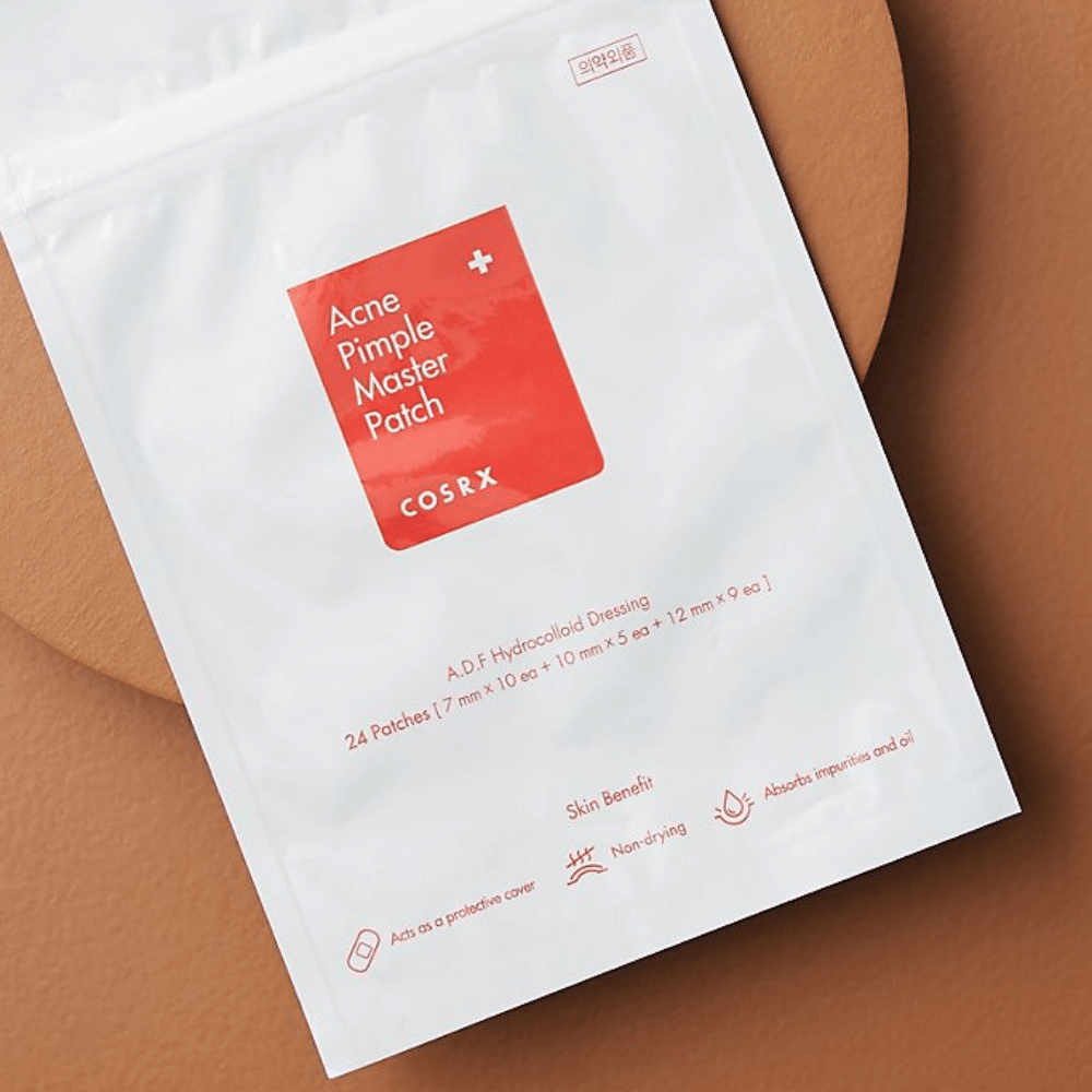 En pakke COSRX Acne Pimple Master Patch (1pakke x 24 plaster) på en brun bakgrunn, med hydrokolloidteknologi for å behandle akne og kviser.