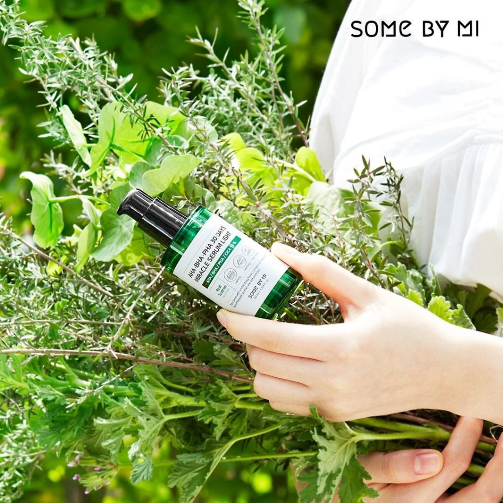 En kvinne som holder en bunt urter i hendene for å motvirke pigmentflekker og akne ved hjelp av AHA, BHA, PHA 30 Days Miracle Serum Light 50ml fra SOME BY MI.