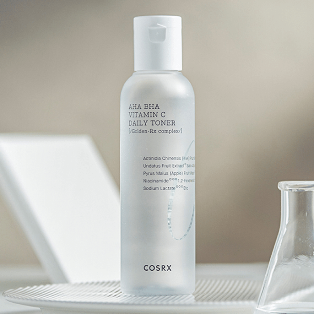 En flaske COSRX Refresh AHA BHA Vitamin C Daily Toner 150ml som sitter oppå en hvit plate.