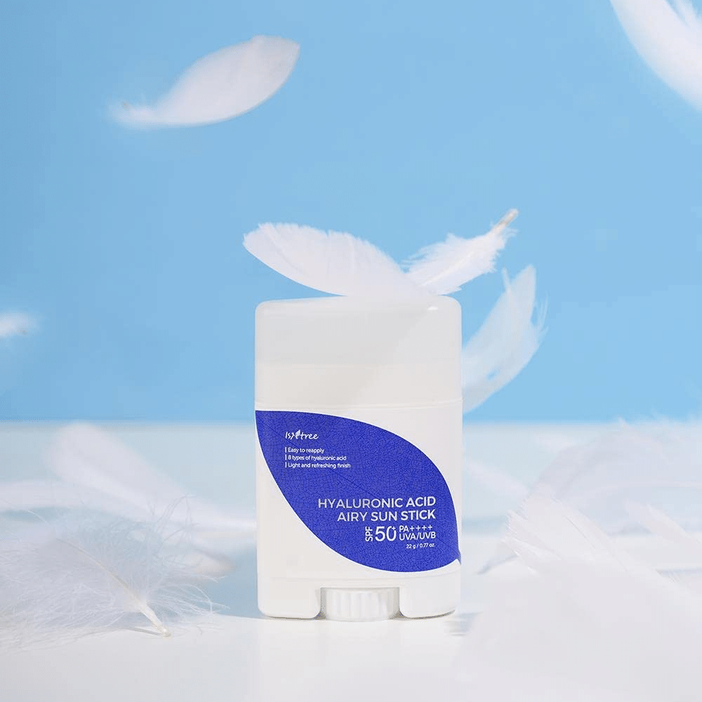 En Isntree Hyaluronic Acid Airy Sun Stick med SPF 50+ og hyaluronsyre, prydet med hvite fjær.