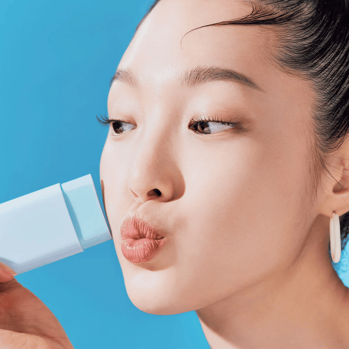 En kvinna använder en TOCOBO Cotton Soft Sun Stick SPF50+ PA++++ 19g för att rengöra ansiktet.