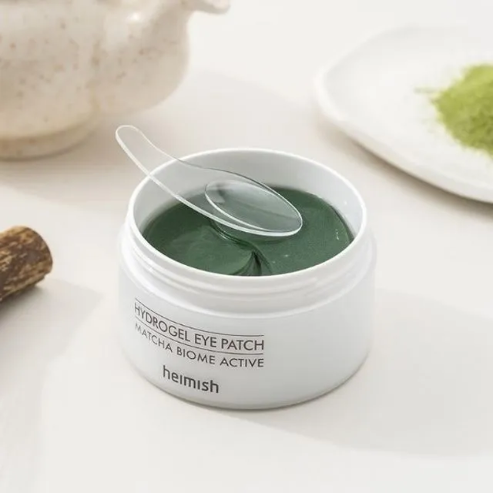 En bolle med Heimish Matcha Biome Hydrogel Eye Patch 60 plaster med en skje.